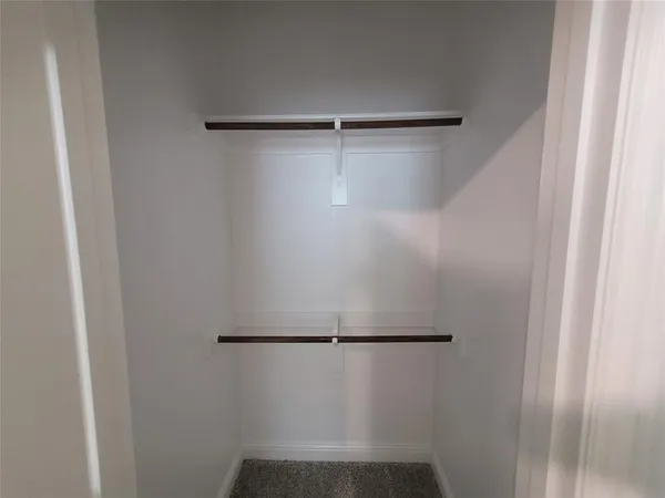 an empty room with a window and closet