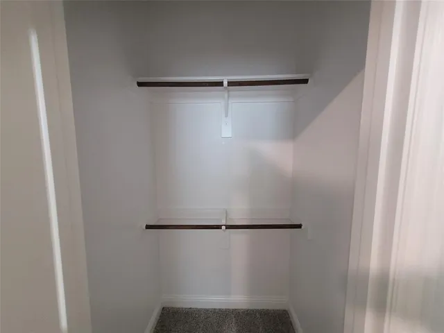 an empty room with a window and closet
