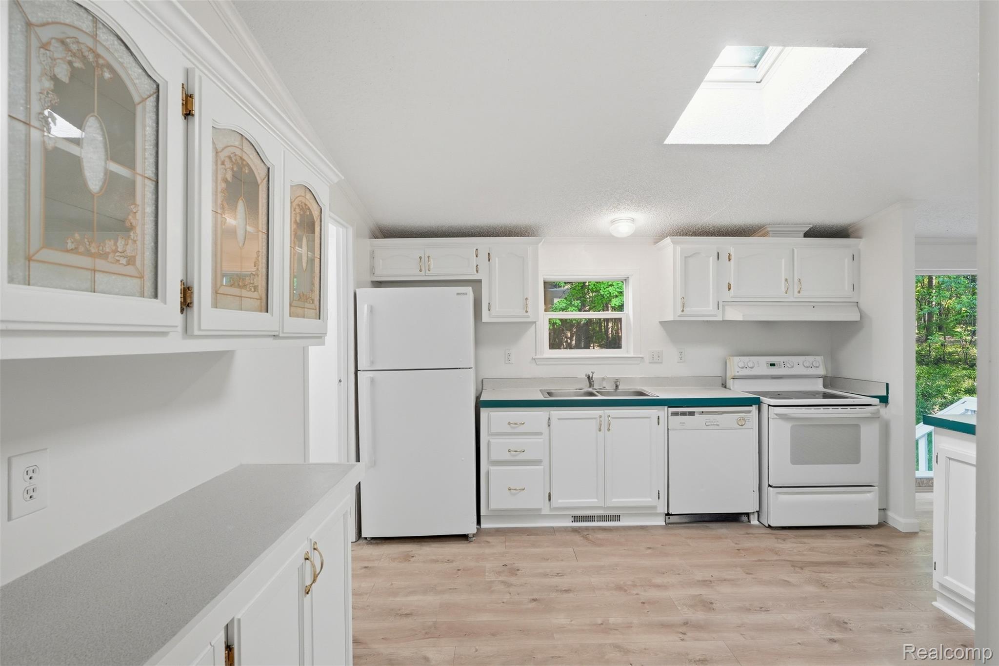 3432 Stanton Road Oxford, MI 48371 - Photo 14 of 48 Kitchen featuring wood-finish flooring, white cabinetry, and a skylight