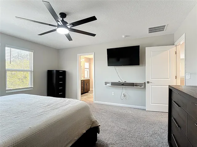 a spacious bedroom with a large bed and a flat screen tv