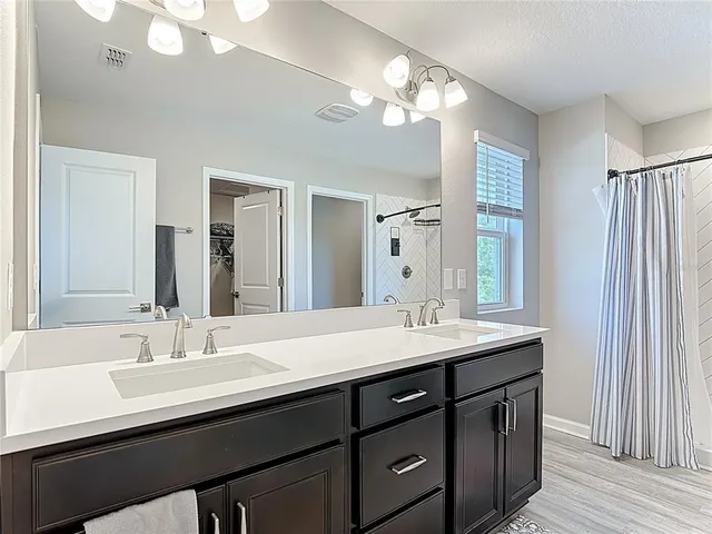 a bathroom with double vanity sinks and a mirror