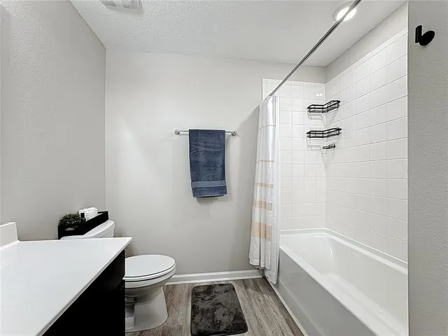 a bathroom with a sink a toilet a tub and shower