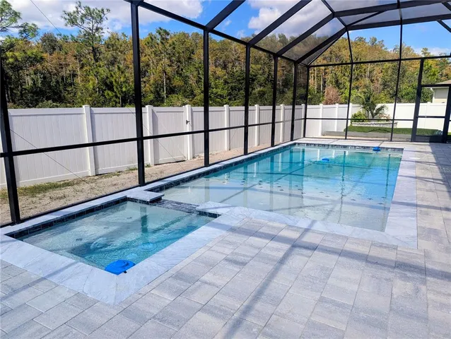 an aerial view of a house with a yard and pool