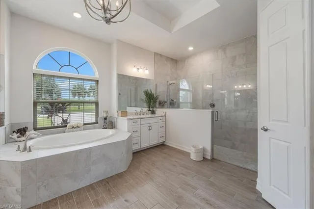 a large bathroom with a tub double vanity sink and mirror