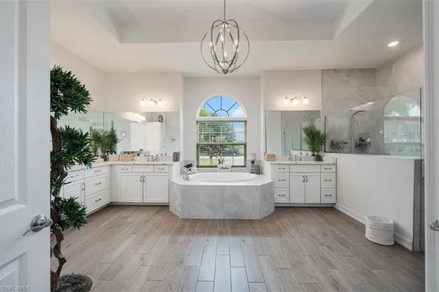 a kitchen with a white cabinets and chandelier