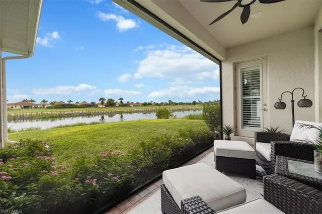 a view of a patio with lawn chairs floor to ceiling window and an outdoor kitchen