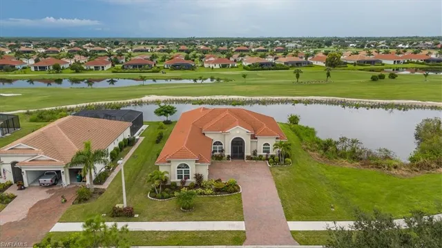 an aerial view of a house with a garden and lake view