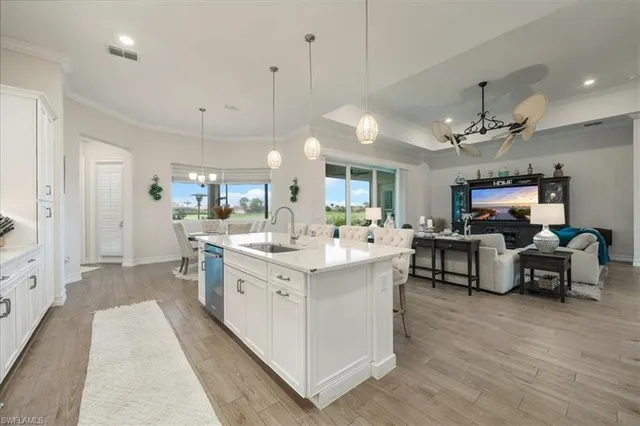 a large white kitchen with cabinets a sink and a stove