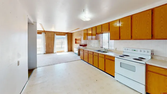 a kitchen with stainless steel appliances a sink cabinets and a large window