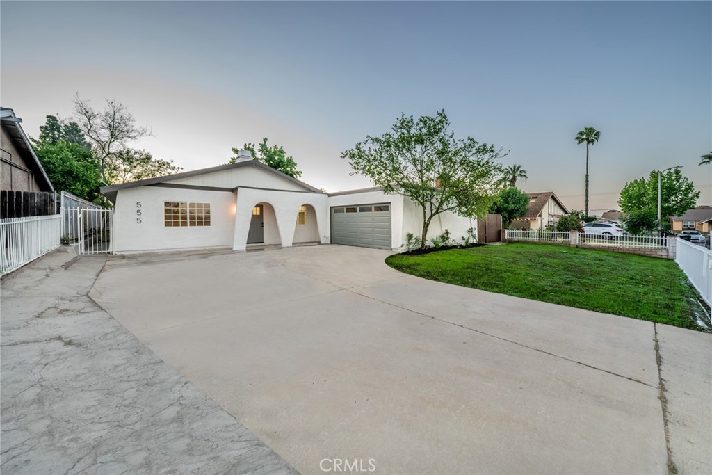 555 North Chestnut Avenue Rialto, CA 92376 - Photo 1 of 33 a front view of a house with a yard and potted plants