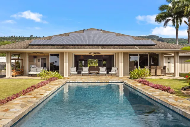 front view of a house with a swimming pool and a lounge chair