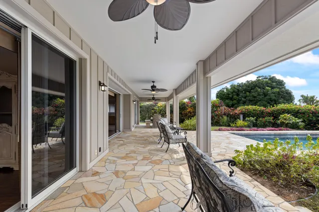 a view of a patio with table and chairs potted plants with floor to ceiling window