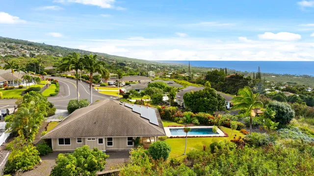 an aerial view of residential houses with outdoor space and trees