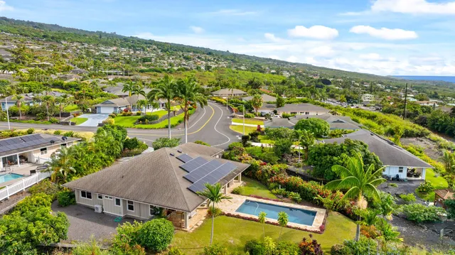 an aerial view of residential houses with outdoor space and trees
