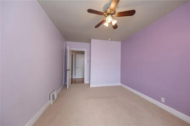 wooden floor in an empty room with a fan