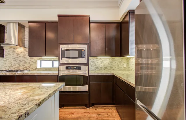 a kitchen with stainless steel appliances granite countertop wooden cabinets and a counter top