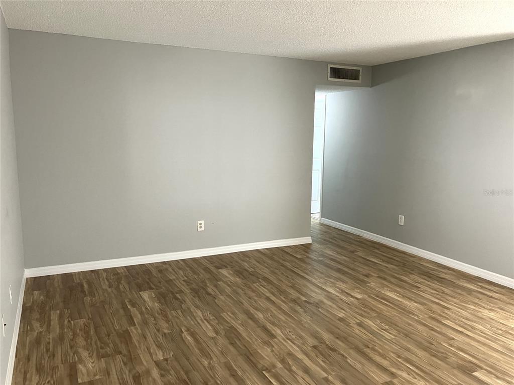 11703 Raintree Village Boulevard, Unit B Temple Terrace, FL 33617 - Photo 11 of 60 a view of an empty room with wooden floor
