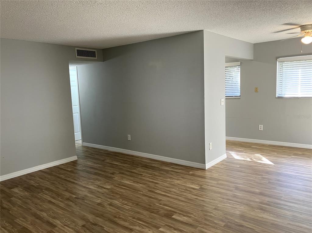 11703 Raintree Village Boulevard, Unit B Temple Terrace, FL 33617 - Photo 12 of 60 a view of an empty room with wooden floor and a window