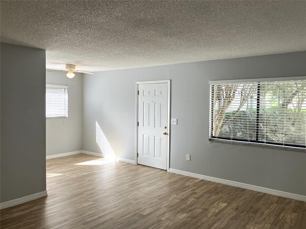 11703 Raintree Village Boulevard, Unit B Temple Terrace, FL 33617 - Photo 13 of 60 a view of empty room with wooden floor and fan