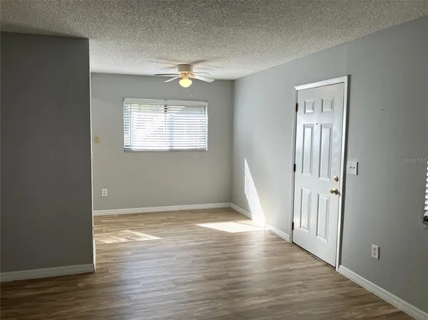 a view of a kitchen with wooden floor and a refrigerator
