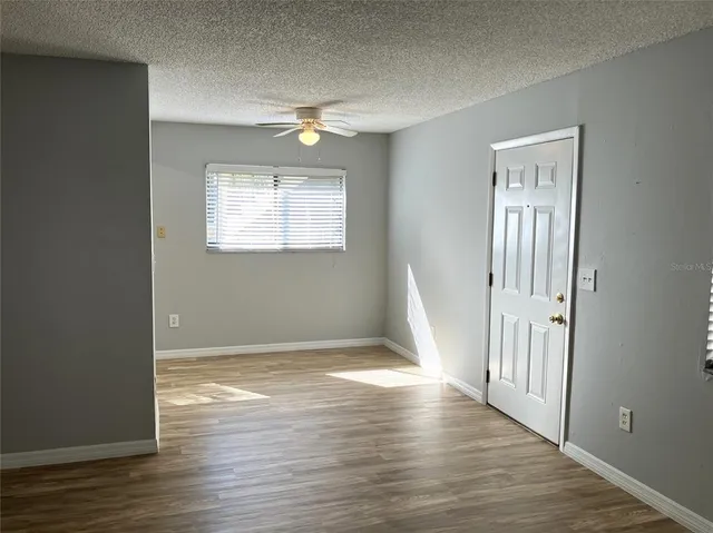 a view of a kitchen with wooden floor and a refrigerator