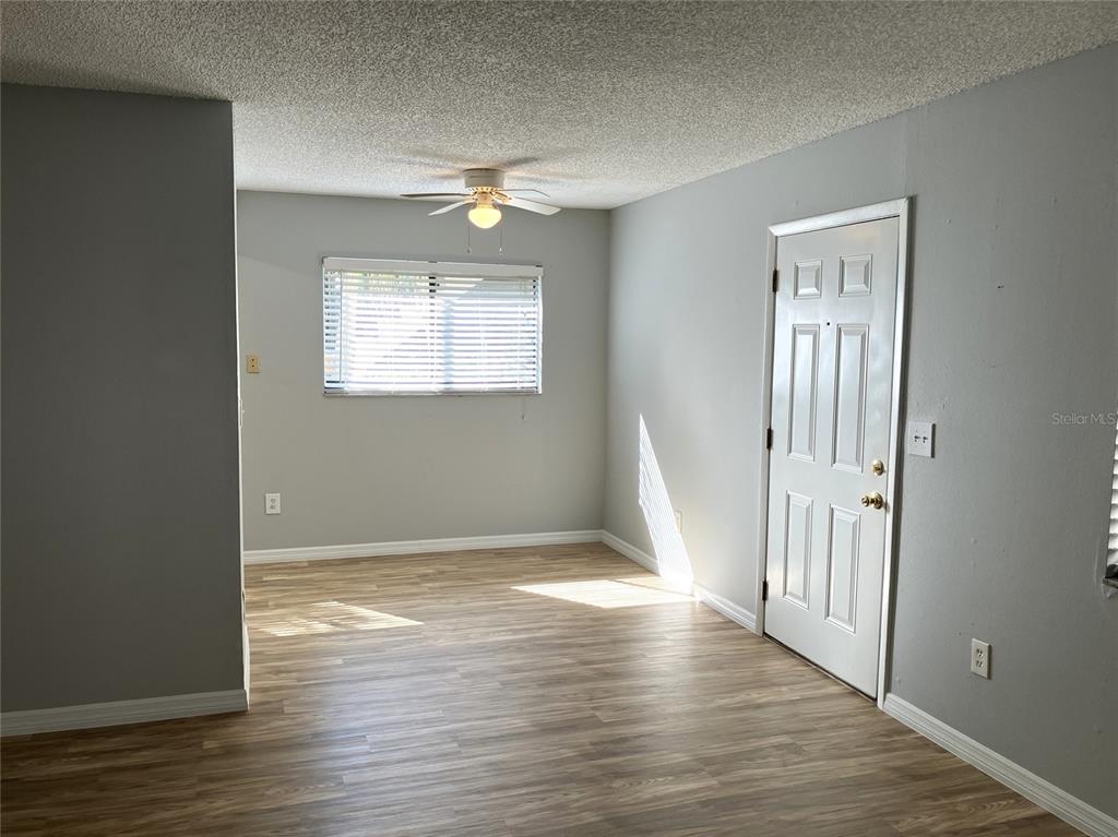 11703 Raintree Village Boulevard, Unit B Temple Terrace, FL 33617 - Photo 14 of 60 an empty room with wooden floor and windows