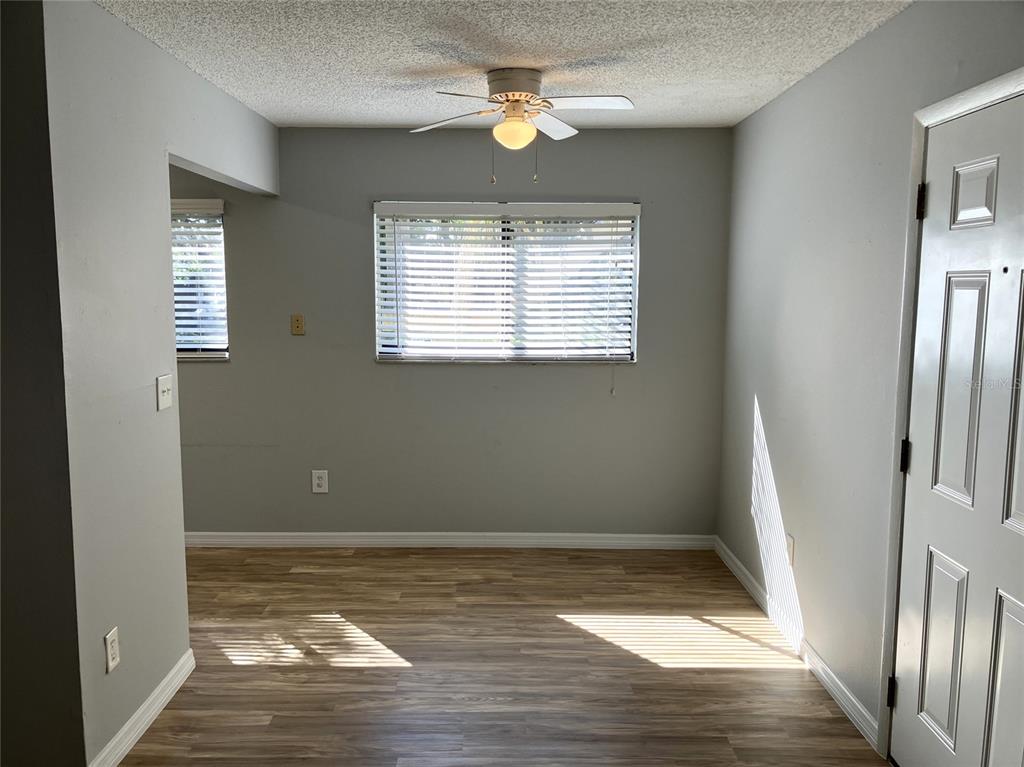 11703 Raintree Village Boulevard, Unit B Temple Terrace, FL 33617 - Photo 15 of 60 a view of an empty room with a window and wooden floor