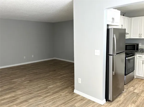 a kitchen with granite countertop white cabinets and appliances