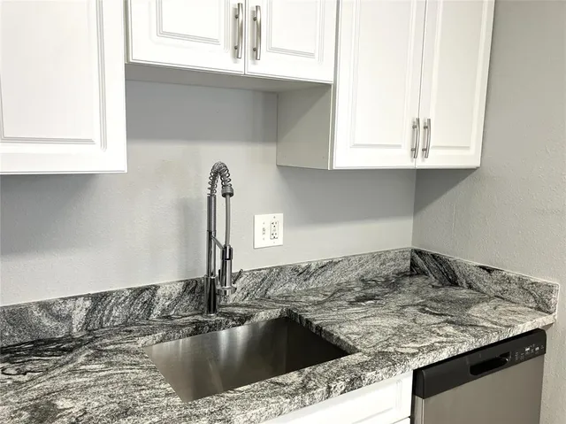 a view of a kitchen with wooden floor and electronic appliances