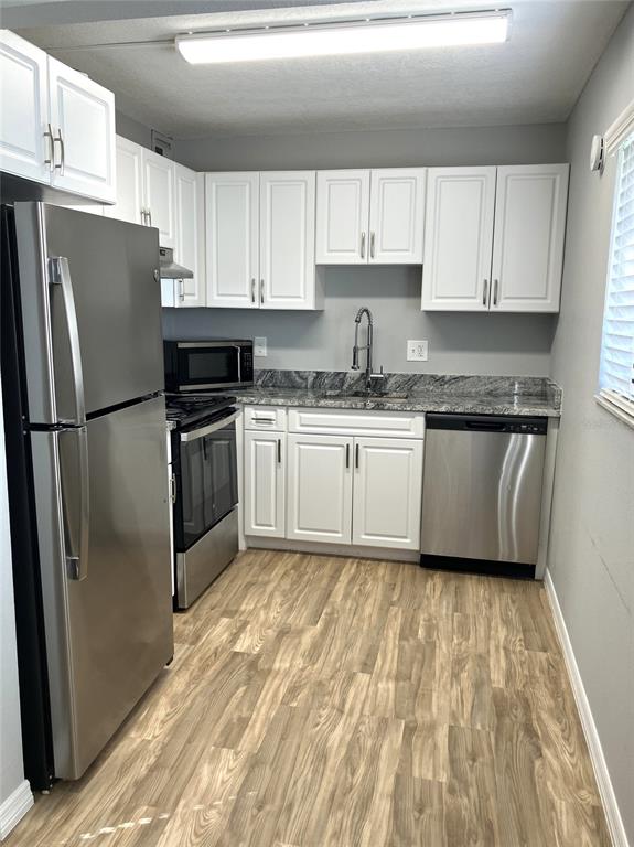 11703 Raintree Village Boulevard, Unit B Temple Terrace, FL 33617 - Photo 26 of 60 a kitchen with granite countertop a refrigerator sink and white cabinets