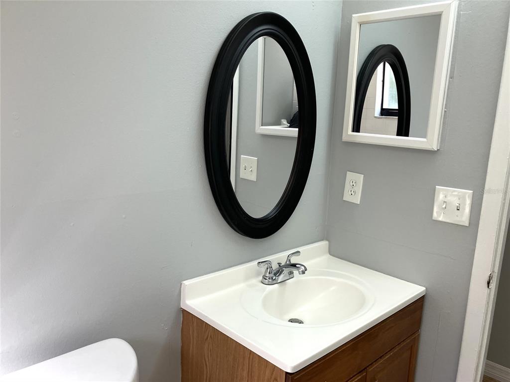 11703 Raintree Village Boulevard, Unit B Temple Terrace, FL 33617 - Photo 37 of 60 a bathroom with a toilet sink and mirror