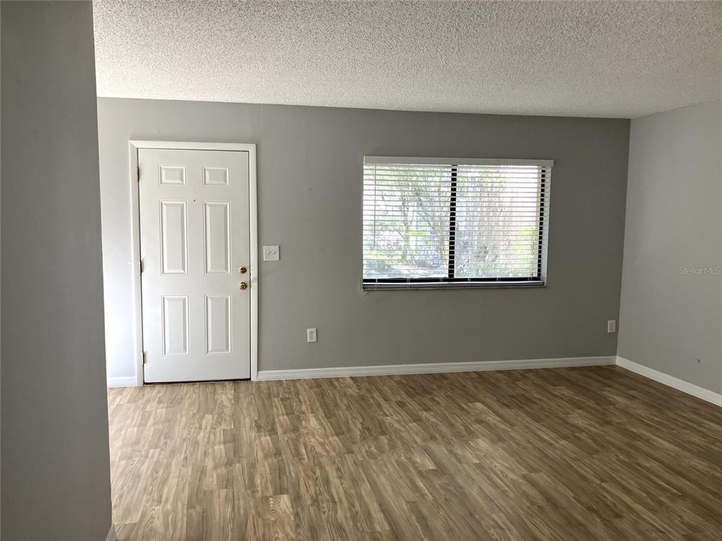 11703 Raintree Village Boulevard, Unit B Temple Terrace, FL 33617 - Photo 8 of 60 an empty room with wooden floor and windows