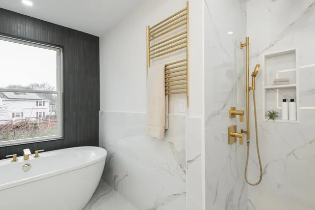 a bathroom with a white bath tub sitting next to a window