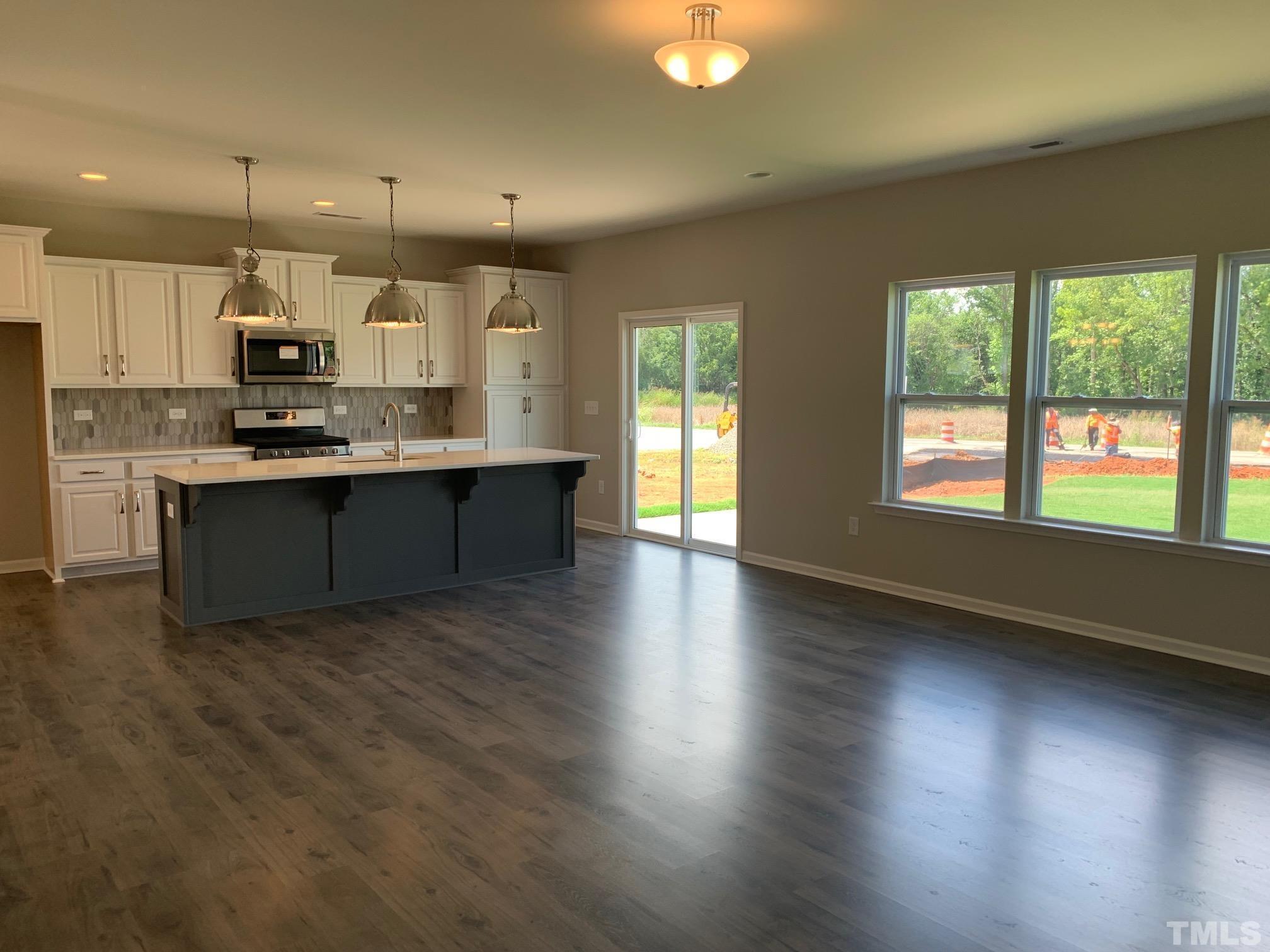 7104 Commodity Court Mebane, NC 27302 - Photo 15 of 32 a large kitchen with stainless steel appliances granite countertop a stove and a large window