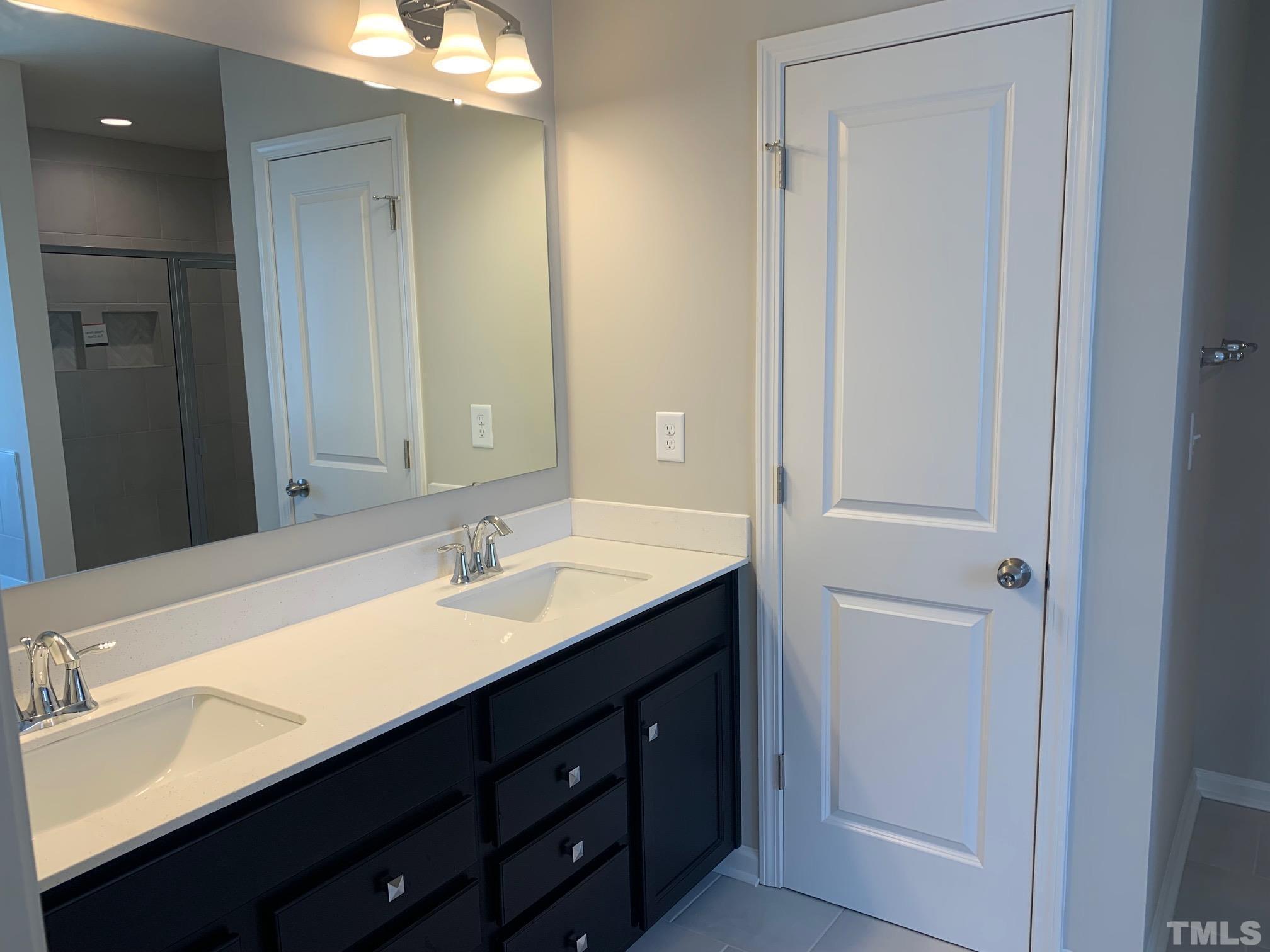 7104 Commodity Court Mebane, NC 27302 - Photo 19 of 32 a bathroom with a double vanity sink and a mirror