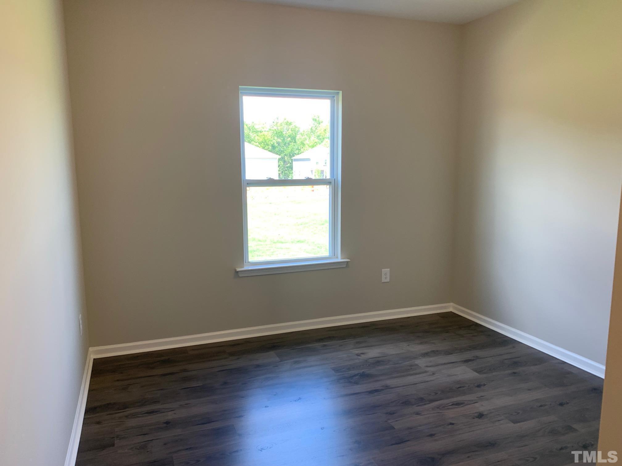 7104 Commodity Court Mebane, NC 27302 - Photo 4 of 32 an empty room with wooden floor and a window