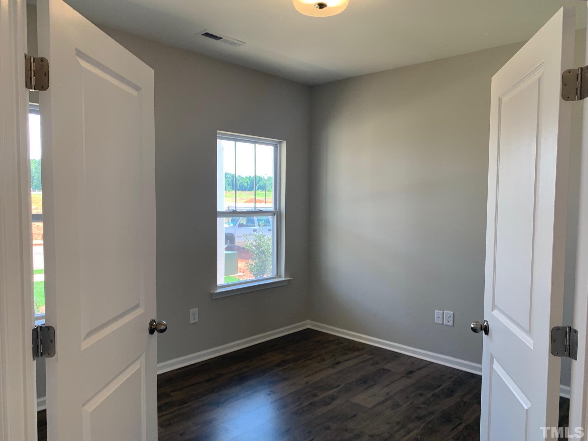 7104 Commodity Court Mebane, NC 27302 - Photo 9 of 32 an empty room with wooden floor and windows