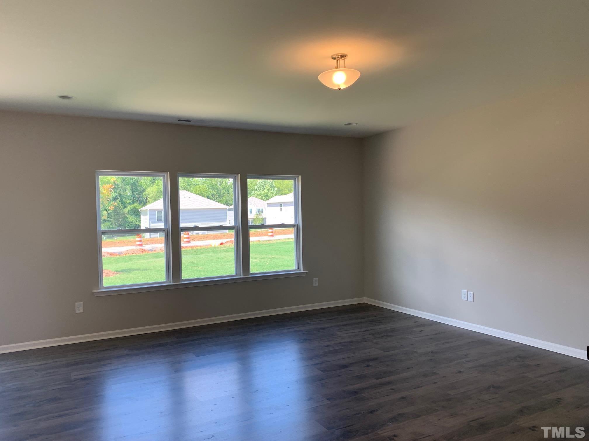 7104 Commodity Court Mebane, NC 27302 - Photo 10 of 32 an empty room with wooden floor and windows