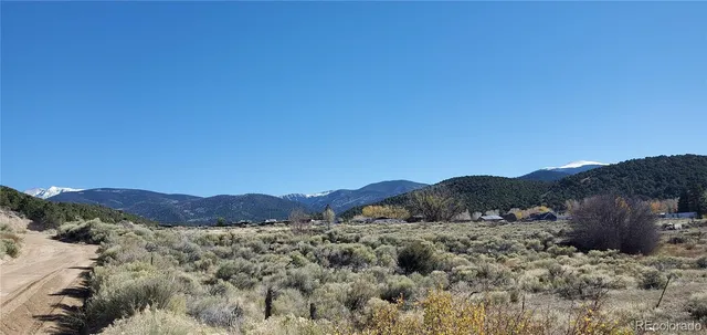 a view of a dry yard with mountains in the background