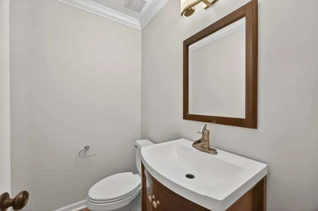 a bathroom with a toilet a sink and mirror