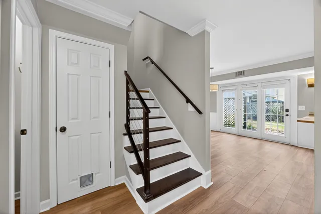 a view of front door with wooden floor and stairs