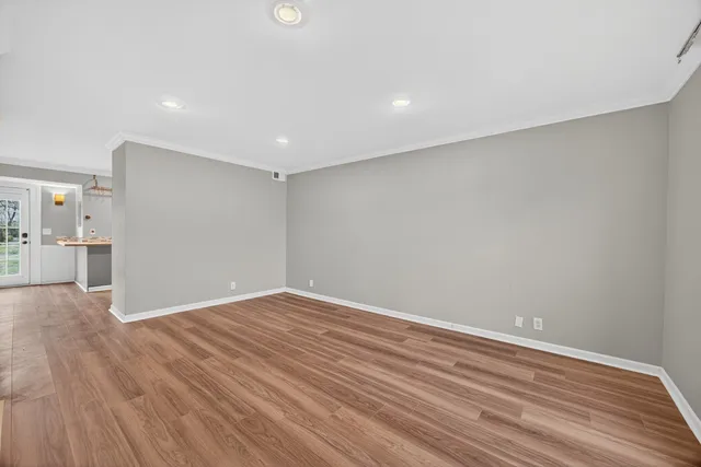 a view of empty room with wooden floor