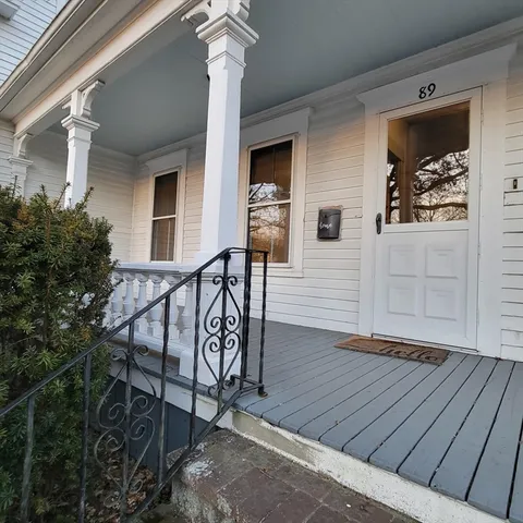 a wooden bench sitting in front of a house
