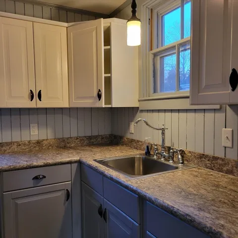 a kitchen with granite countertop a sink and cabinets