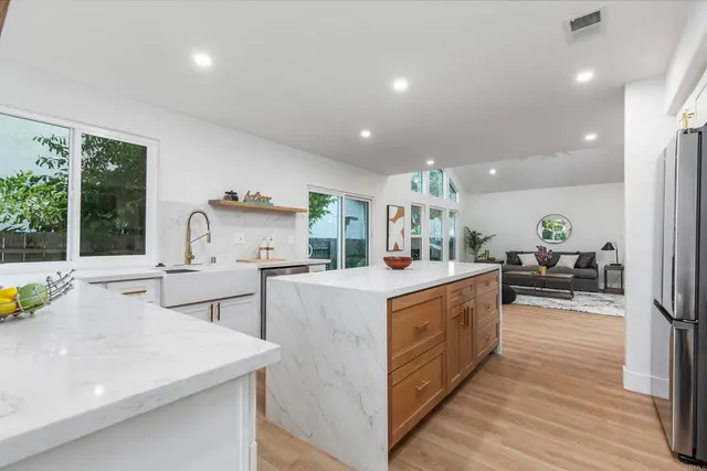 a kitchen with appliances cabinets and a potted plant
