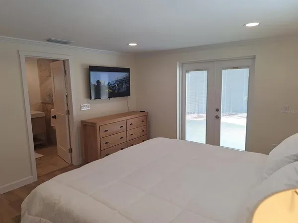 a spacious bedroom with a bed and a flat screen tv