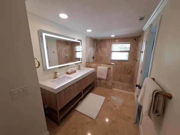 a bathroom with a granite countertop sink and a bathtub