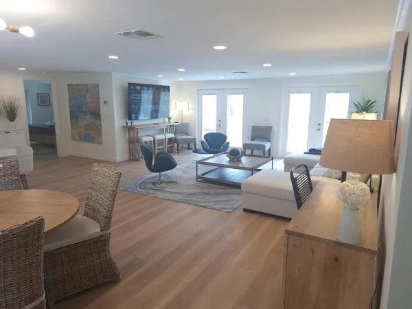 a living room with furniture kitchen view and a large window