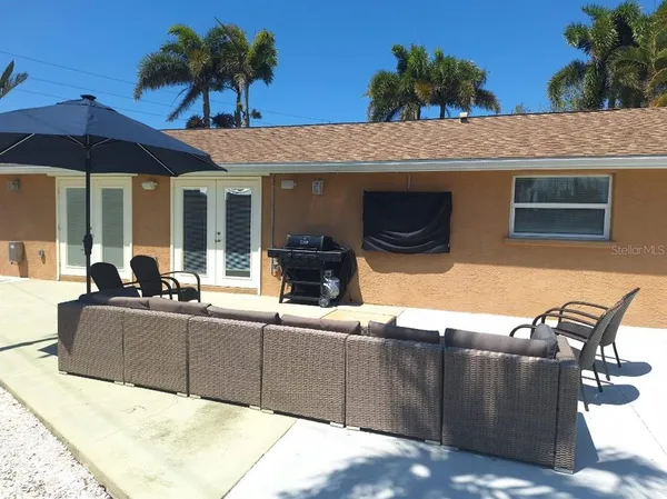 a view of a terrace with chairs and an umbrella