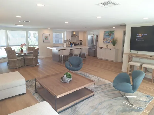 a living room with furniture a flat screen tv and kitchen view